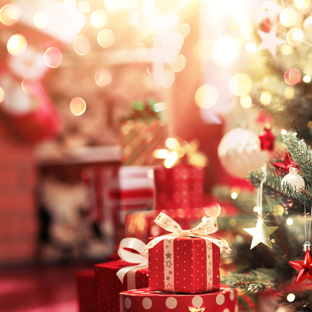 Christmas tree with toys and gifts on the background of a fireplace with fire